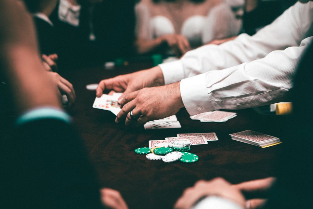 Tumpukan kartu poker dan chip di atas meja felt hijau